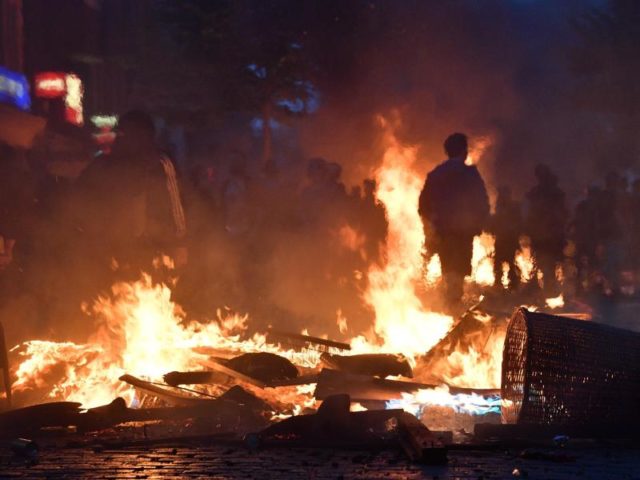 Aktivisten stehen im Hamburger Schanzenviertel vor einer brennenden Barrikade. Foto: Boris Roessler/dpa