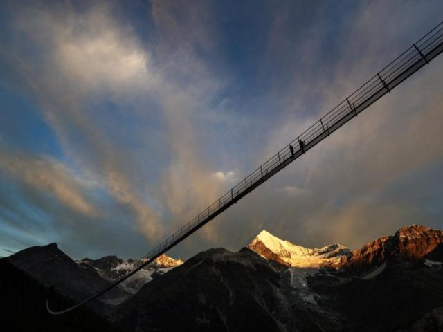 «Europabrücke» im schweizerischen Randa. Die fast 500 Meter lange Hängebrücke lädt schwindelfreie Wanderer in der Schweiz seit Samstag zur Überquerung des Grabengufers bei Zermatt ein. Foto: Valentin Flauraud/dpa