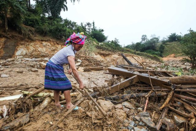 This picture taken on August 4, 2017 shows a Hmong hilltribe woman searching for household items from the rubble of her home after it was destroyed in flash floods in the mountainous district of Mu Cang Chai in the northern province of Yen Bai.<br /> Floods and landslides caused by torrential rains have killed 26 people and left 15 missing in Vietnam's mountainous northern provinces, authorities said on August 7. / AFP PHOTO / STR (Photo credit should read STR/AFP/Getty Images)
