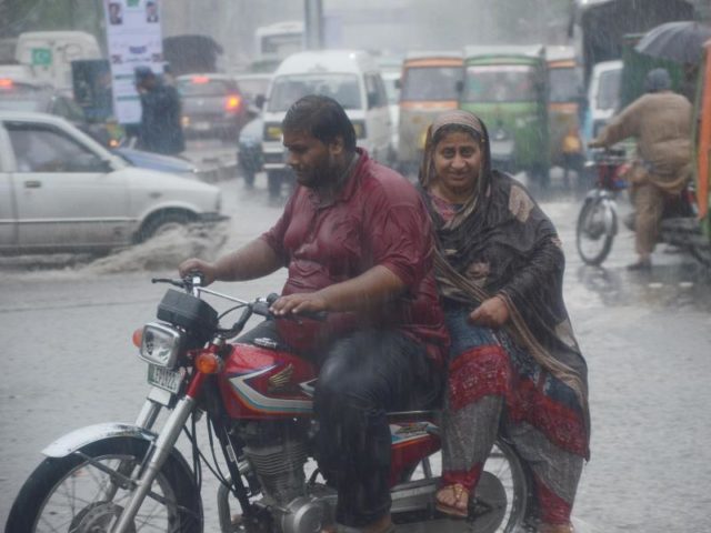 Ein Paar fährt über eine überschwemmte Straße in Lahore, Pakistan. Meteorologen warnen weiterhin vor viel Regen im Süden Pakistans. Foto: Rana Sajid Hussain/Pacific Press/dpa