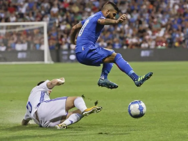 Der Italiener Lorenzo Insigne (r) weicht einer Grätsche von Israels Amor Melikson aus. Foto: Luca Bruno/dpa