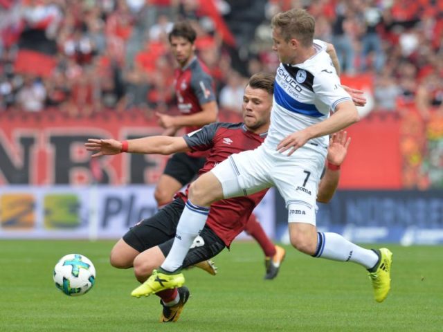 Der Nürnberger Eduard Löwen (l) kommt beim Kampf um den Ball gegen den Bielefelder Patrick Weihrauch zu Fall. Foto: Timm Schamberger/dpa