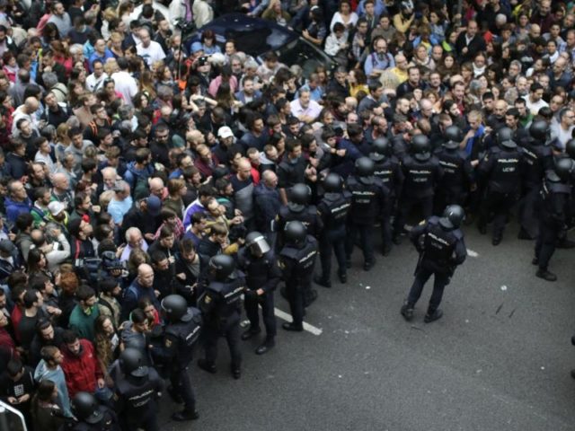 Einheiten der spanischen Nationalpolizei hindern Menschen daran, ihre Stimme beim Referendum abzugeben. Foto: Emilio Morenatti/dpa