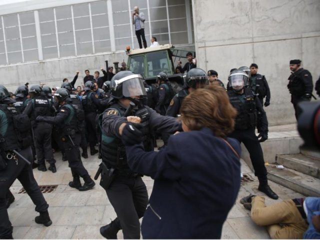 Einheiten der Guardia Civil, der spanischen Nationalpolizei, gehen in Santa Julia de Ramis bei Girona gegen Menschen vor, die vor einem zum Wahllokal umfunktionierten Sportcenter warten. Foto: Francisco Seco/dpa
