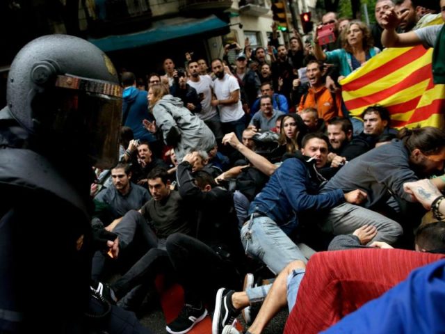 Spanische Polizisten und katalanische Demonstranten: Insgesamt wurden im Zusammenhang mit der Abstimmung etwa 900 Menschen verletzt. Foto: Manu Fernandez/dpa