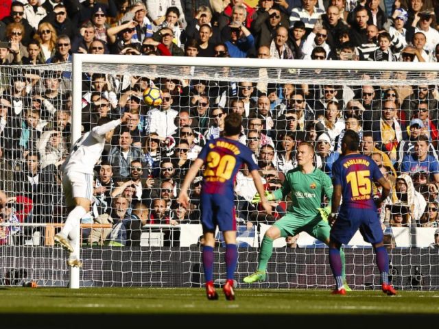 Cristiano Ronaldo (l) köpft den Ball auf das Tor mit Marc-Andre ter Stegen vom FC Barcelona. Foto: Enrique de la Fuente/dpa