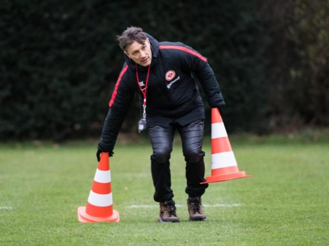 Frankfurts Chef-Trainer Niko Kovac räumt beim Trainingsauftakt Hütchen weg. Foto: Andreas Arnold/dpa