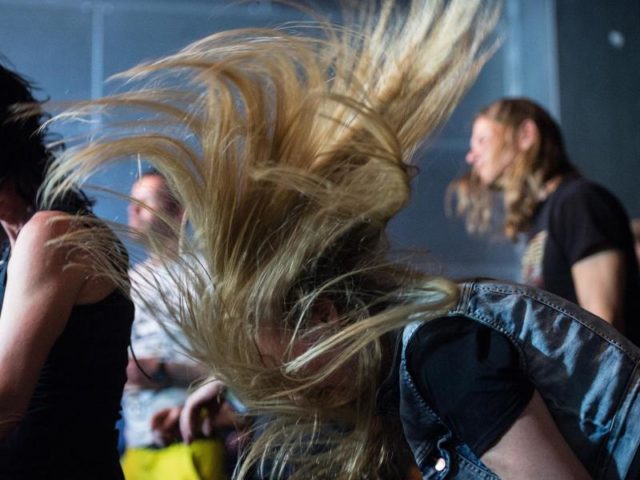 Weiblicher Metal-Fan beim Headbanging. Foto: Henrik Josef Boerger/dpa