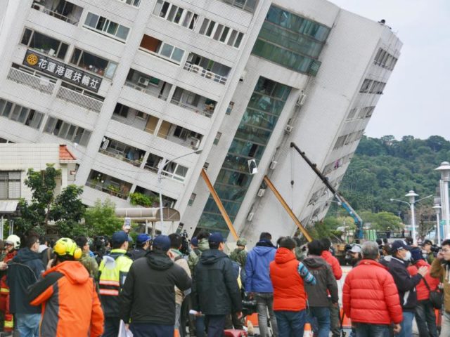 Schaulustige haben sich in Hualien vor dem nun schief stehenden Yuntsui Building versammelt. Foto: kyodo/dpa