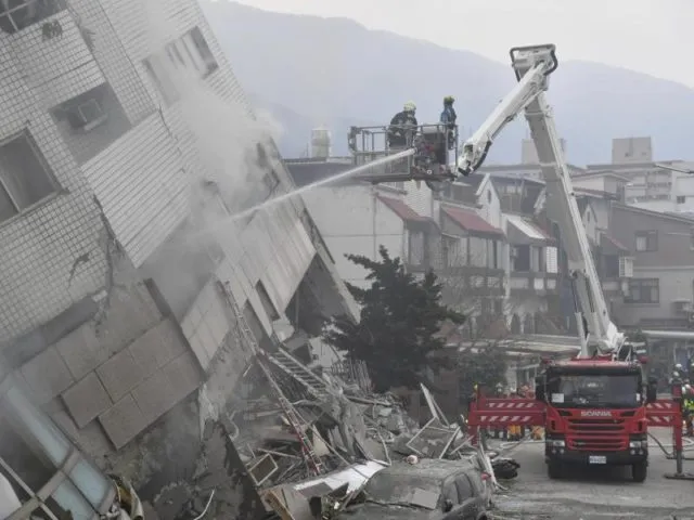 Das zwölfstöckige Wohnhaus neigt sich gefährlich zur Seite, weil die untersten Etagen eingestürzt sind. Foto: Central News Agency/dpa