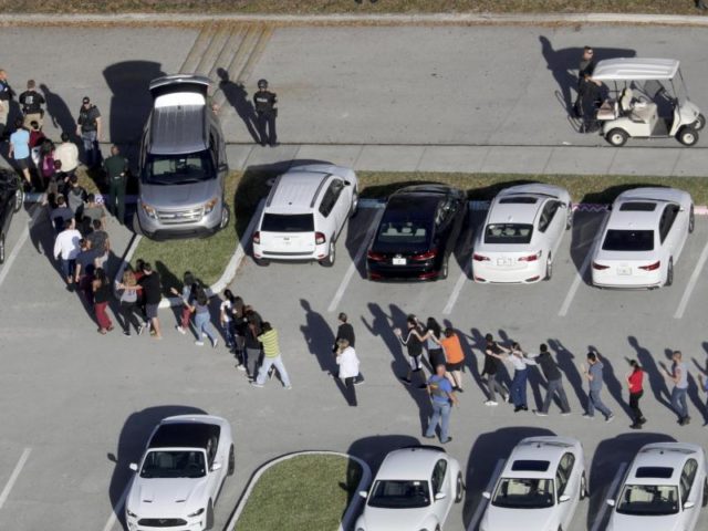 Schüler verlassen mit erhobenen Händen das Schulgelände. Foto: Mike Stocker/South Florida Sun-Sentinel/AP/dpa