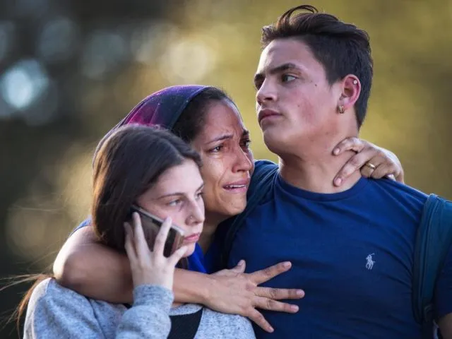 Überlebt: Eine Angehörige umarmt zwei Schüler der Marjory Stoneman Douglas High School nach den tödlichen Schüssen. Foto:&nbsp;Greg Lovett/Palm Beach Post via ZUMA Wire/dpa