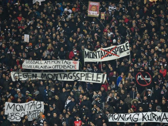 Fans von Eintracht Frankfurt halten zu Spielbeginn Plakate als Protest gegen das Montagsspiel in die Höhe. Foto: Uwe Anspach/dpa