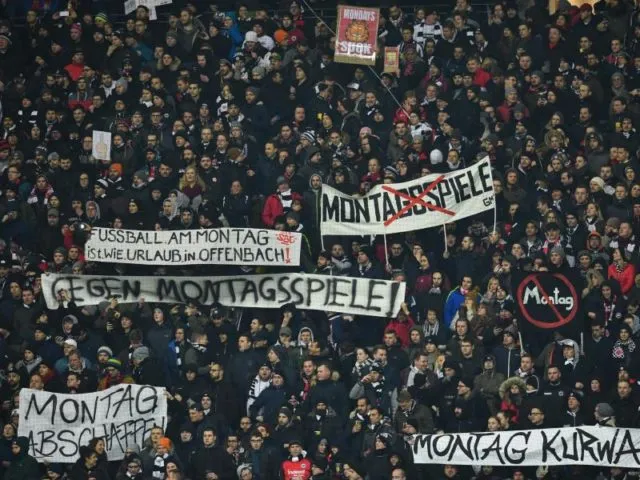 Fans von Eintracht Frankfurt halten zu Spielbeginn Plakate als Protest gegen das Montagsspiel in die Höhe. Foto: Uwe Anspach/dpa