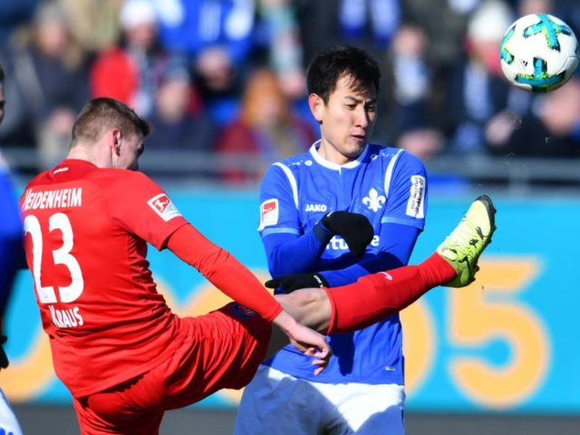 Heidenheims Kevin Kraus (l) und Darmstadts Dong-Won Ji kämpfen um den Ball. Foto: Uwe Anspach/dpa