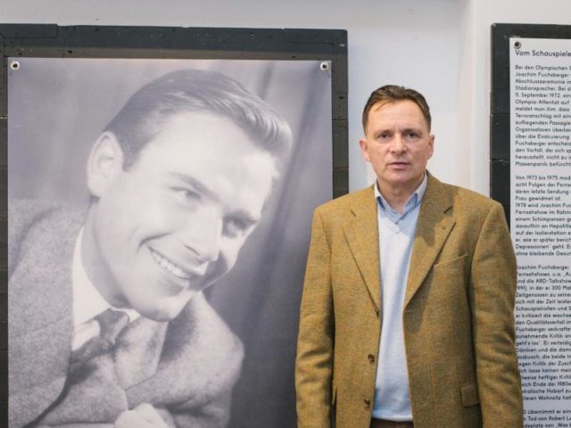Der Leiter des Theatermuseums, Carsten Niemann, neben einem Porträt Joachim Fuchsbergers. Foto: Ole Spata/dpa
