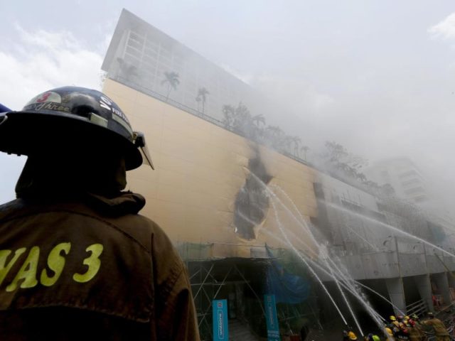 Feuerwehrleute bei einem Brand im Manila Pavilion Hotel & Casino. Mehr als 300 Gäste mussten aufgrund des Brandes evakuiert werden. Foto: Bullit Marquez/dpa