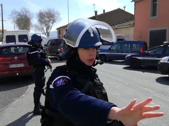 Polizisten sichern während einer Geiselnahme in einem Ort am Rande von Carcassonne eine Straße. Foto: La Depeche Du Midi/dpa