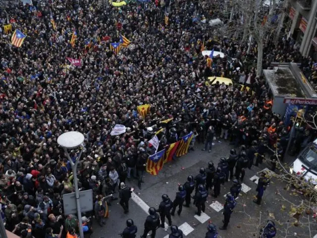 Polizisten blockieren den Weg von Demonstranten. Foto: Emilio Morenatti, AP/dpa