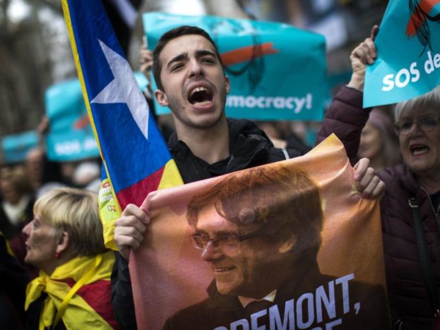 Ein Demonstrant hält ein Poster mit einem Bild des abgesetzten ehemaligen Präsidenten Puigdemont. Foto: Emilio Morenatti, AP/dpa