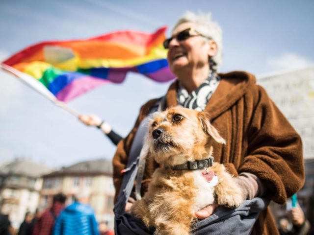 Zusammen mit ihrem Hund nimmt eine Frau an der Abschlusskundgebung auf dem Frankfurter Römerberg teil. Foto: Frank Rumpenhorst/dpa