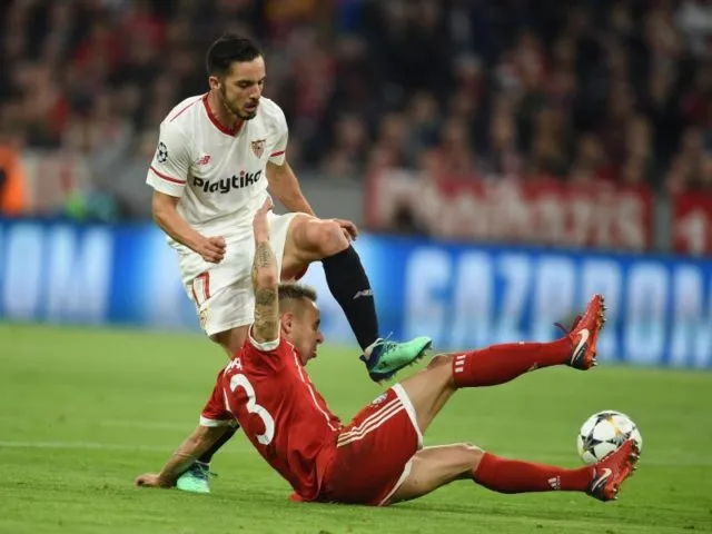 Bayerns Rafinha (unten) grätscht Sevillas Pablo Sarabia Garcia den Ball vom Fuß. Foto: Andreas Gebert/dpa