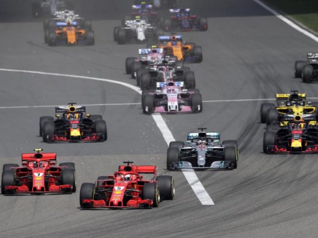 Beim Start zum China-Rennen kommt Kimi Räikkönen besser weg als Ferrari-Teamkollege Sebastian Vettel auf der Pole. Foto: Andy Wong/AP/dpa