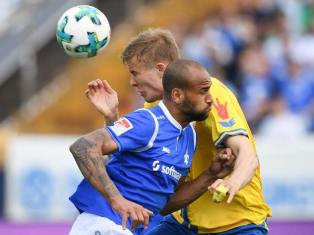 Darmstadts Terrence Boyd (vorn) und Braunschweigs Frederik Tingager versuchen an den Ball zu kommen. Foto: Arne Dedert/dpa