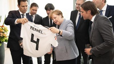 Angela Merkel bekommt Fußballtrikot geschenkt