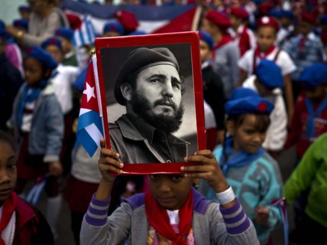 Ein Mädchen hält in Havanna ein Porträt des kubanischen Revolutionsführers Fidel Castro hoch. Zur 59. Wiederkehr der Ankunft von ihm und seiner Rebellenarmee auf der Insel versammeln sich Kubaner auf den Straßen. Foto: Ramon Espinosa/AP/dpa