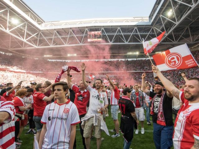 Die Mannschaft von Fortuna Düsseldorf jubelt mit ihren Fans über den Aufstieg. Foto: Bernd Thissen/dpa