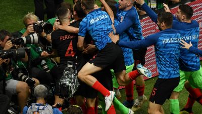 Jubelnde National-Elf Kroatiens überrennt AFP-Fotografen am Spielfeldrand
