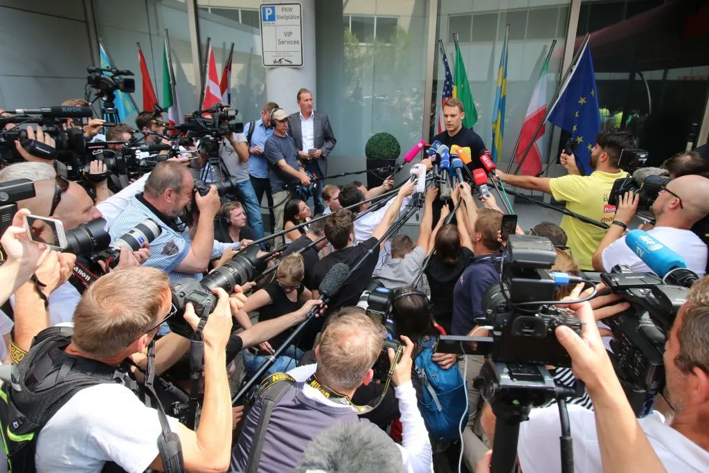Deutschlands Torhüter Manuel Neuer spricht mit den Medien, als er am 28. Juni 2018 am Frankfurter Flughafen ankommt, nachdem er nach der Niederlage der deutschen Fußballnationalmannschaft bei der Fußball-WM 2018 aus Moskau zurückgeflogen ist. Foto: YANN SCHREIBER/AFP/Getty Images