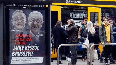 Anti-Orban-Aktivisten überkleben Poster gegen Juncker und Soros