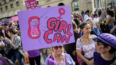 „Schweiz mit feministischem Streik lahmlegen”: Frauen streiken mit rosafarbener Klitoris und geballter Faust