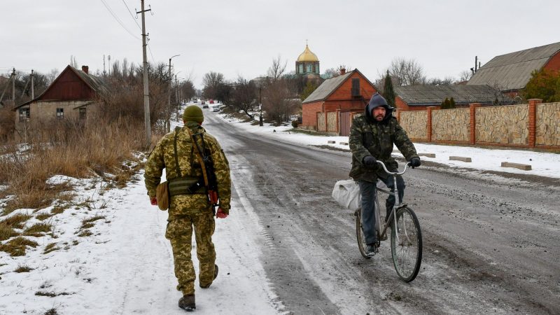 Ein ukrainischer Soldat patrouilliert eine Straße.