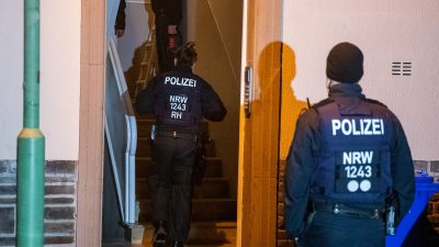 Einsatzkräfte der Polizei durchsuchen ein Mehrfamilienhaus in Essen.