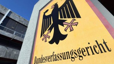 Ein Hinweisschild mit Bundesadler und Schriftzug «Bundesverfassungsgericht» hängt vor dem Bundesverfassungsgericht.