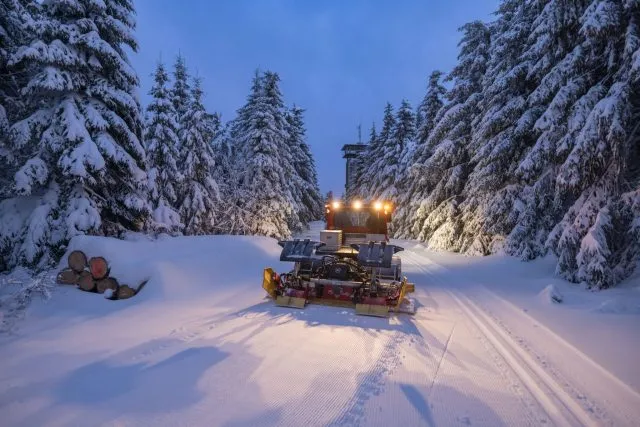 Mit einem Pistenbully spurt ein Mitarbeiter am frühen Morgen die Loipen für die Gäste des Wintersportortes Masserberg in Thüringen.