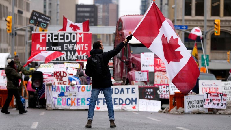 Ein Demonstrant schwenkt bei einem Protest gegen die Corona-Maßnahmen in Ottawa eine kanadische Flagge.