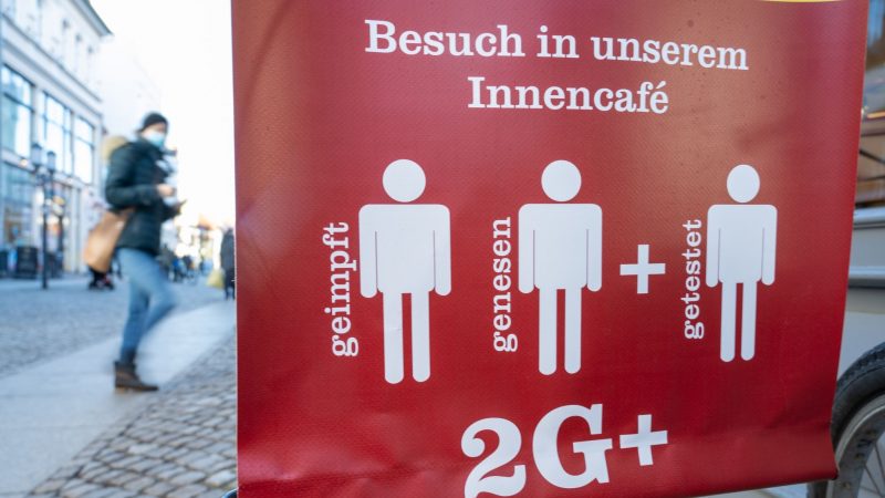 Ein Schild weist auf die 2G Plus Regel in einem Café im Ostseebad auf Rügen hin.