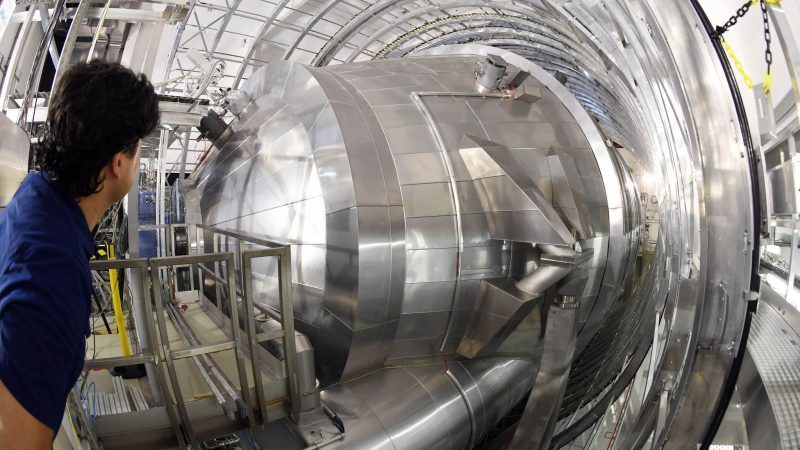 Ein Mitarbeiter des Karlsruher Tritium Neutrino Experiments (Katrin) am Karlsruher Institut für Technologie (KIT) blickt auf das Hauptspektrometer der Anlage. Mit dem Experiment soll die Masse von Neutrinos mit bis dato nicht möglicher Genauigkeit gemessen werden.