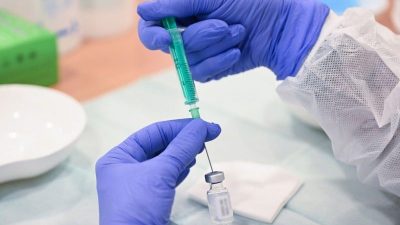 Eine Mitarbeiterin des Klinikums Stuttgart bereitet in einer Impfstation eine Spritze für eine Impfung gegen das Coronavirus vor.