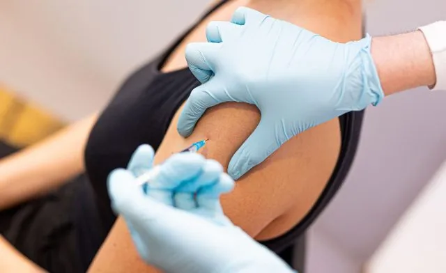 Eine Frau wird von einem Arzt gegen das Coronavirus geimpft.