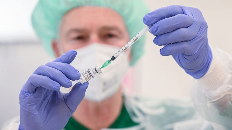 Ein Mitarbeiter des Klinikums Stuttgart bereitet in einer Impfstation eine Spritze für eine Impfung gegen das Coronavirus vor.
