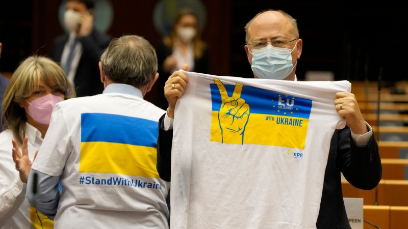 Ein Mitglied des Europäischen Parlaments hält ein T-Shirt in den Farben Blau und Gelb zur Unterstützung der Ukraine.