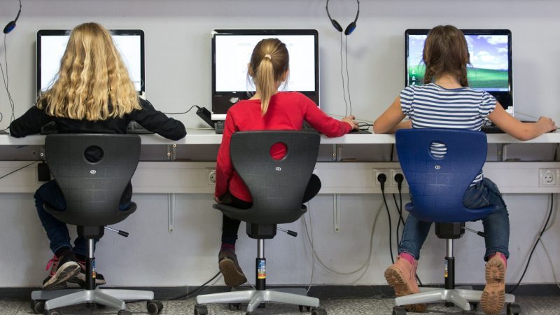 Schülerinnen arbeiten in einem Klassenraum einer Grundschule an Computern.