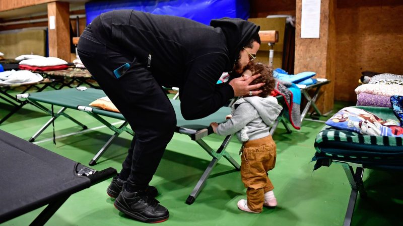 Ein aus der Ukraine geflüchteter Vater kümmert sich in einer ungarischen Notunterkunft um seine Tochter.