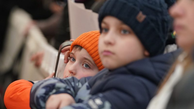 Zwei Brüder, die mit ihrer Mutter aus der Ukraine geflohen sind, warten im Zelt vor der Registrierungsstelle für Flüchtlinge in Hamburg-Marienthal auf Einlass.