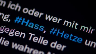 Die Hashtags Hass und Hetze in einem Twitter-Post auf einem Smartphone-Bildschirm.